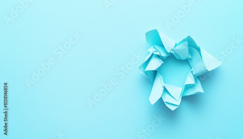 A crumpled piece of blue paper on a matching background, symbolizing creativity and brainstorming.