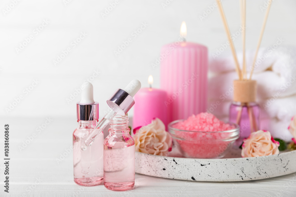Rose essential oil on a textured background.Roses and a bottle of rose perfumed water.Aromatherapy treatment. Beauty concept. Spa procedure.Natural organic oil.Anti-stress,detox relax.Place for text Rose essential oil on a textured background.Roses and a bottle of rose perfumed water.Aromatherapy treatment. Beauty concept. Spa procedure.Natural organic oil.Anti-stress,detox relax.Place for text