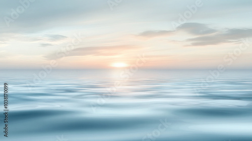 A beautiful blue ocean with a sun setting in the background. The sky is filled with clouds, creating a serene and peaceful atmosphere