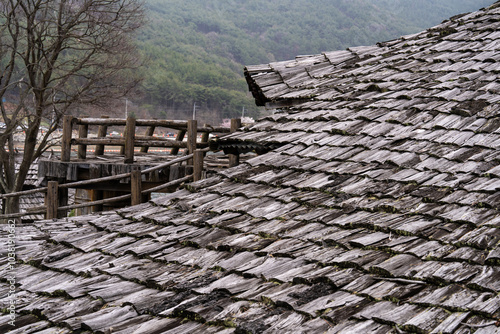 old roof covered with the wooden tiles photo