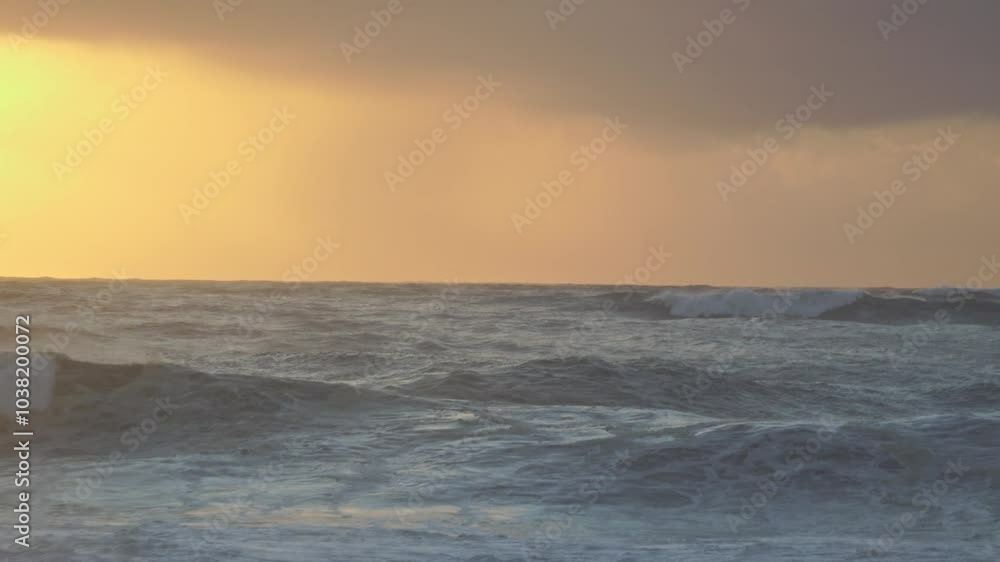 As storm clouds gather at sunset, massive ocean waves crash against the shore, creating a dramatic and turbulent scene. The churning water and dark sky capture the raw power of nature. As storm clouds gather at sunset, massive ocean waves crash against the shore, creating a dramatic and turbulent scene. The churning water and dark sky capture the raw power of nature.