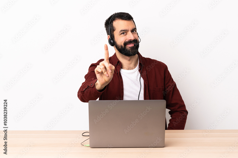 Telemarketer caucasian man working with a headset and with laptop showing and lifting a finger. Telemarketer caucasian man working with a headset and with laptop showing and lifting a finger.