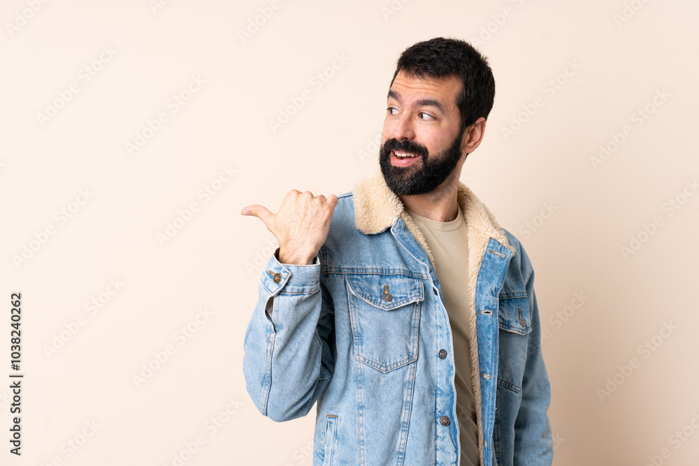 Caucasian man with beard over isolated background pointing to the side to present a product Caucasian man with beard over isolated background pointing to the side to present a product