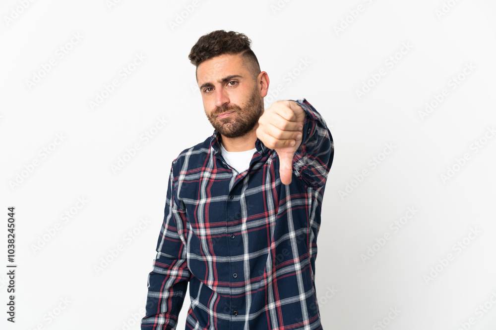 Caucasian man isolated on white background showing thumb down with negative expression Caucasian man isolated on white background showing thumb down with negative expression