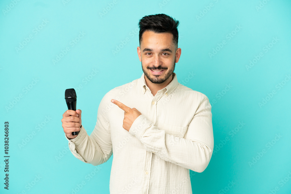 Young caucasian singer man isolated on blue background pointing to the side to present a product Young caucasian singer man isolated on blue background pointing to the side to present a product