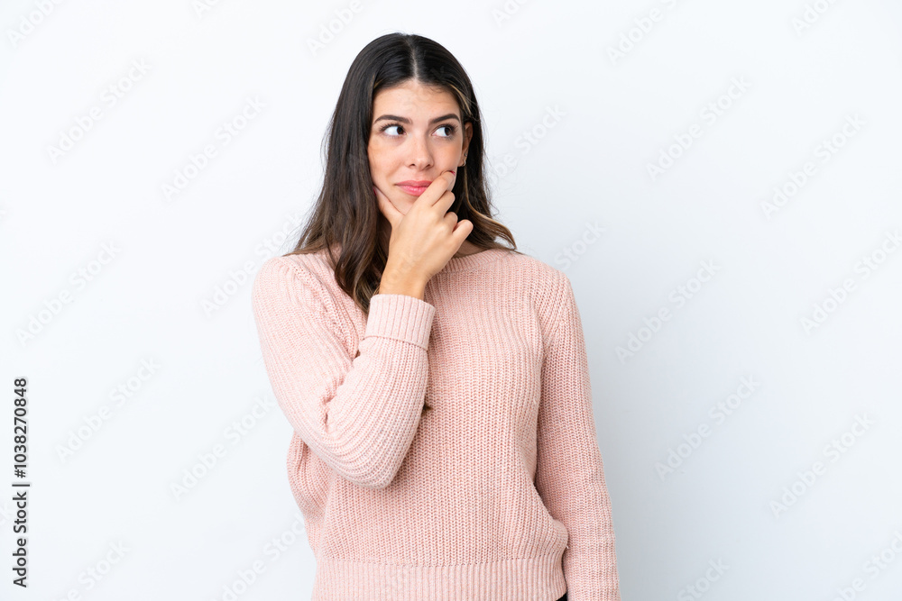 Young Italian woman isolated on white background having doubts and with confuse face expression
