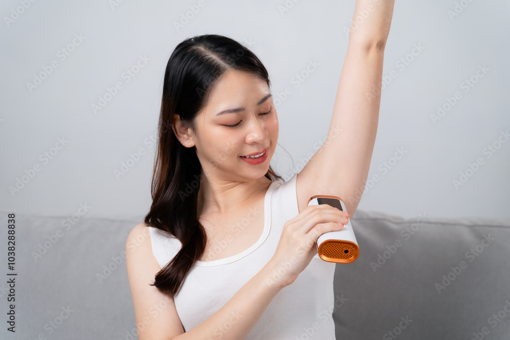 A beautiful woman is epilating her armpits using an IPL laser hair removal epilator device A beautiful woman is epilating her armpits using an IPL laser hair removal epilator device
