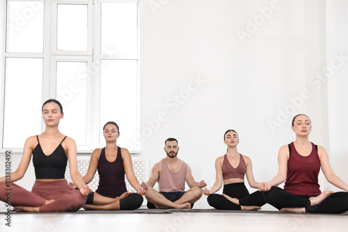 Group of people meditating on mats in yoga class