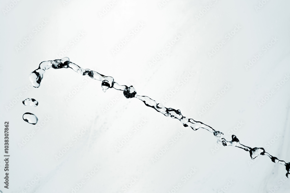 Water splash isolated on blue background. Transparent realistic water with movement and drops. Dynamic flight of water drops. Water splash isolated on blue background. Transparent realistic water with movement and drops. Dynamic flight of water drops.