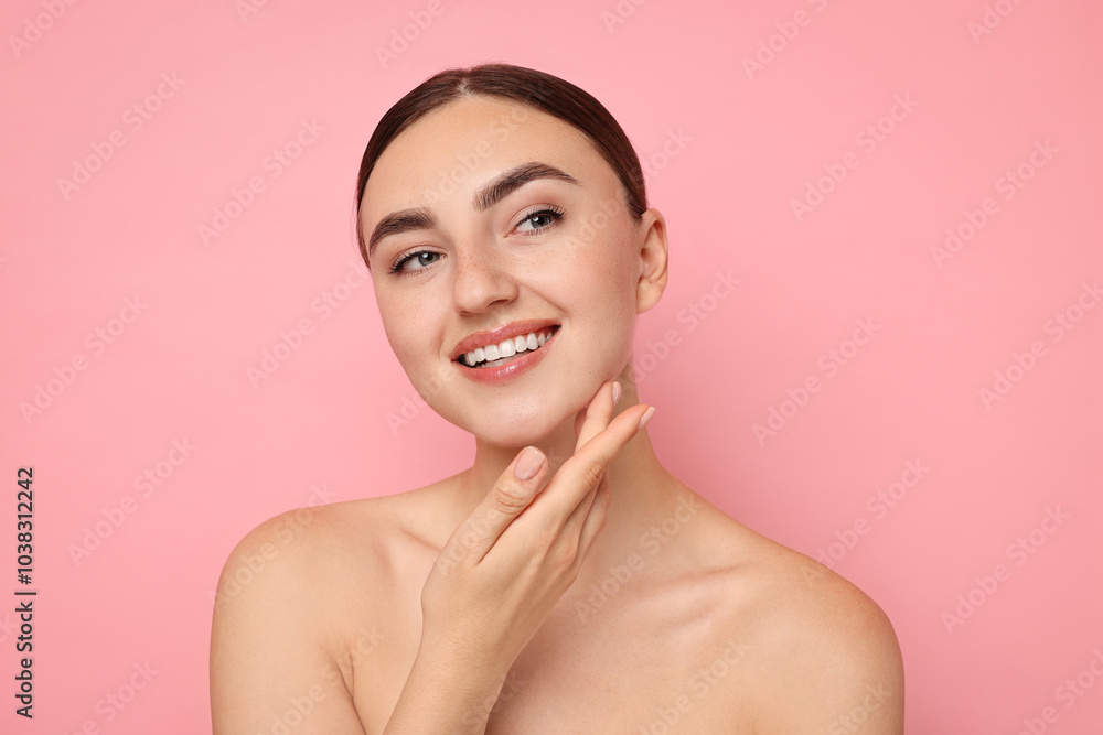 Face massage. Beautiful young woman with healthy skin on pink background Face massage. Beautiful young woman with healthy skin on pink background