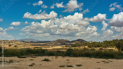 Obraz na płótnie Spanish countryside with mountains and vegetation under blue cloudy sky. w salonie