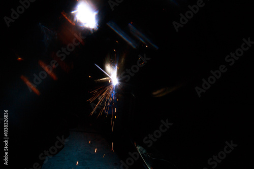 Arc welding. Welding pipes in inert gases. MIG / MAG. A bright flash of light and a sheaf of sparks. photo