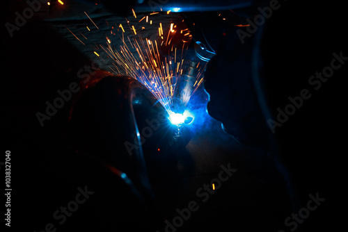 Arc welding. Welding pipes in inert gases. MIG / MAG. A bright flash of light and a sheaf of sparks. photo