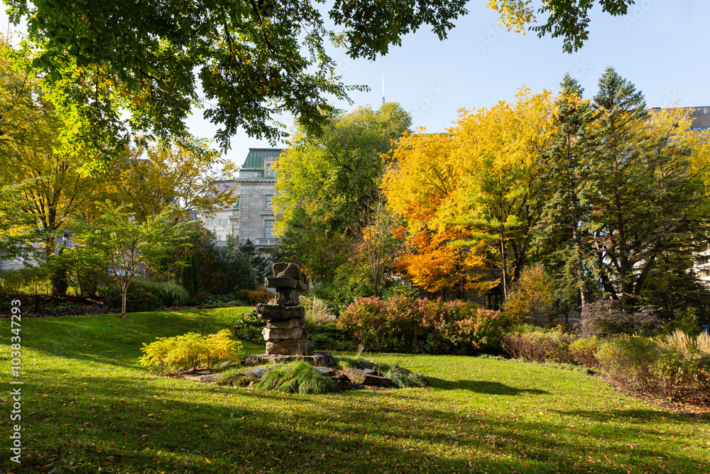 Fototapeta premium The Inuksuk monument on the National Assembly Square seen during a colourful sunny fall day, with the parliament in the background, Quebec City, Quebec, Canada