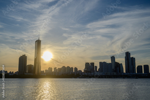 Sunset and silhouette view of 63 Building and high rise buildings of financial district with Wonhyo Bridge on Han River at Yeouido near Yeongdeungpo-gu, Seoul, South Korea photo