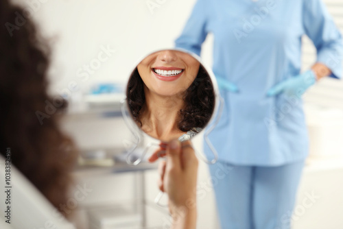 Patient looking in mirror and doctor in clinic, selective focus. Dental veneers