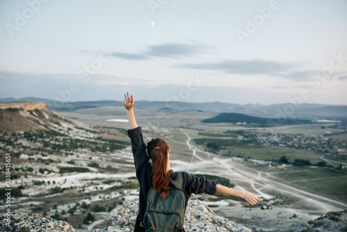 empowered woman embracing the night sky atop mountain peak photo