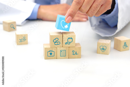 Hand holding a wooden block cube the top one with heart rate icon symbol. Medical and health concept.