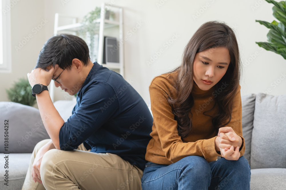 Family problem concept, Close-up hands of Asian wife sitting on sofa and husband sitting back to back in the living room at home have problems in a relationship and have an argument Family problem concept, Close-up hands of Asian wife sitting on sofa and husband sitting back to back in the living room at home have problems in a relationship and have an argument