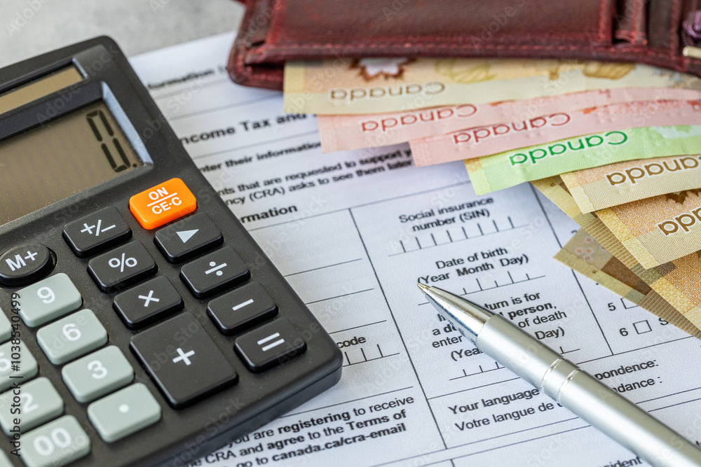 Income tax return in Canada. Financial concept. Tax form, Canadian dollars and tax calculation on calculator. close up