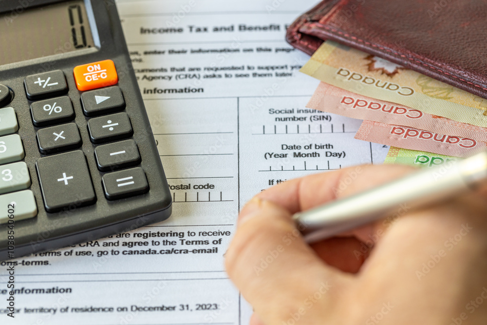 Income tax return in Canada. Financial concept. Tax form, Canadian dollars and tax calculation on calculator. close up