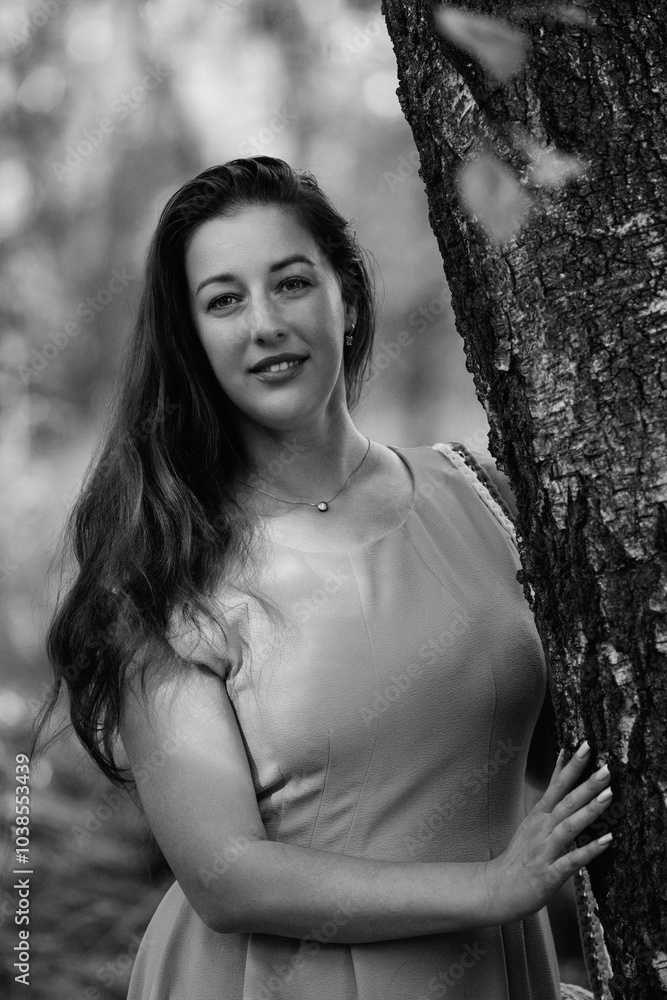 Portrait of a young beautiful dark-haired girl in a light dress in the forest. Black and white photo. Portrait of a young beautiful dark-haired girl in a light dress in the forest. Black and white photo.