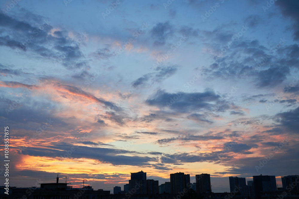 Fototapeta premium Pastel Sunset with Rooftops and City Silhouettes