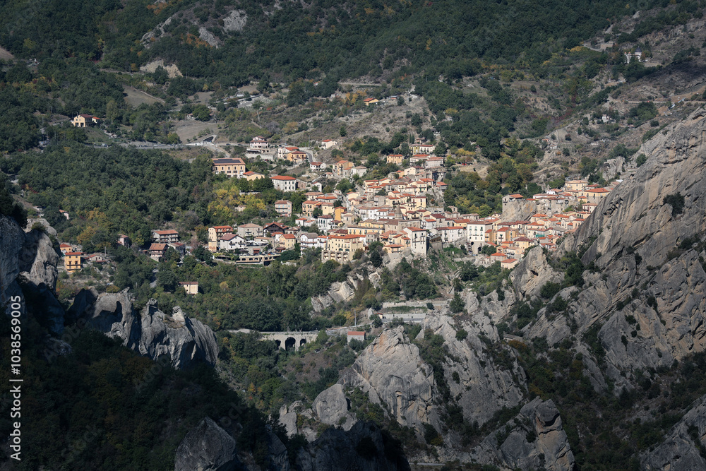 Italian village on hill side surrounded by trees and rocky mountains, sunny day, Castelmezzano, Italy Italian village on hill side surrounded by trees and rocky mountains, sunny day, Castelmezzano, Italy