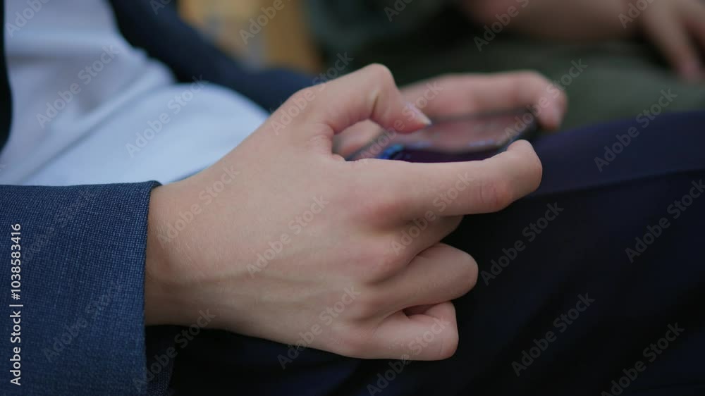 Close-up of a man hands using a phone, He plays a game using mobile internet. Turns the phone vertically. Red light in the evening room
