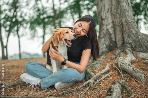 Happy asian woman playing with dog together in public park outdoors, Friendship between human and their pet photo