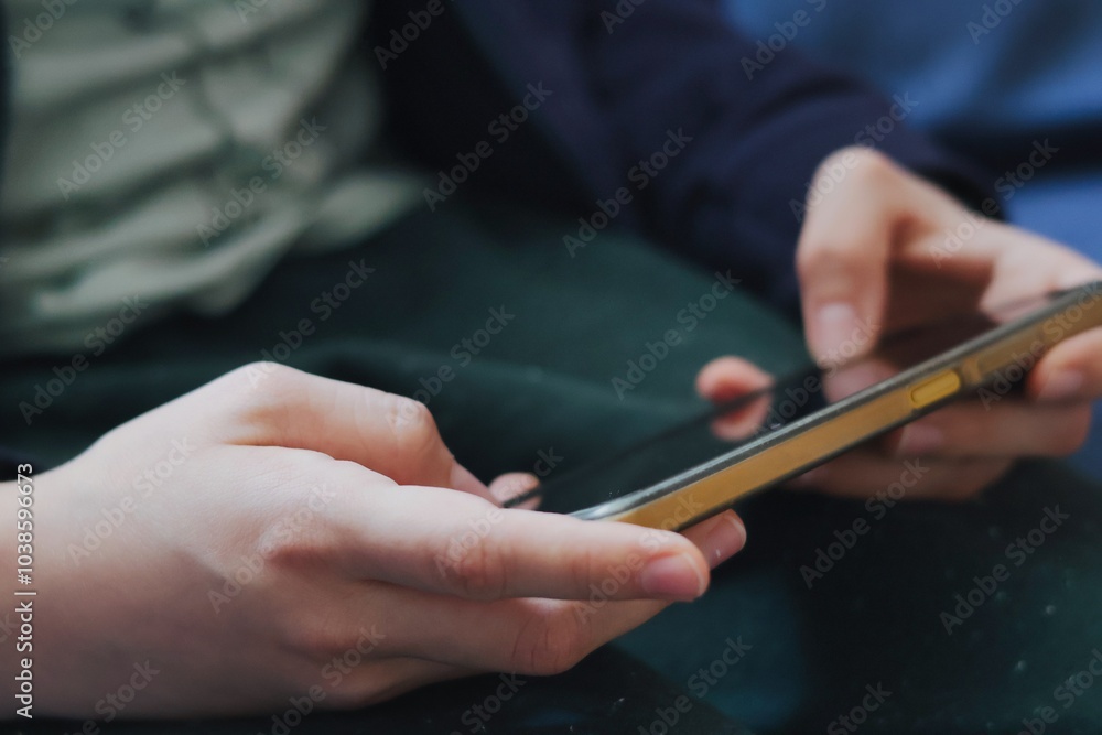 A boy playing a game on a smartphone; Close up of hands and phone A boy playing a game on a smartphone; Close up of hands and phone
