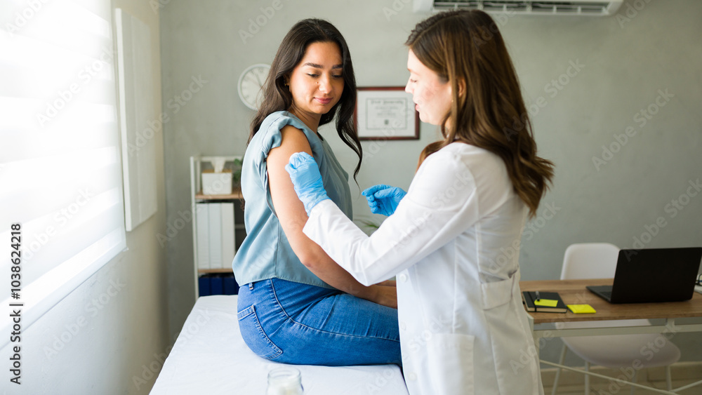 Obraz premium Professional medical worker wearing gloves is vaccinating a young woman in a doctor's office