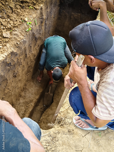 some men are digging a grave for the deceased