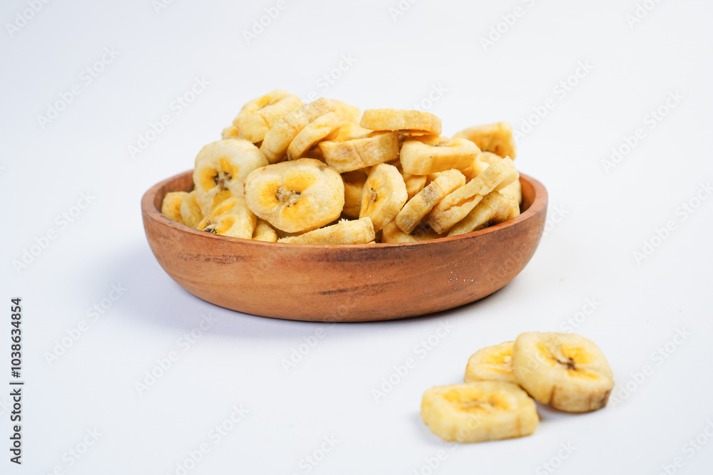 A bowl of banana chips sits on a white background A bowl of banana chips sits on a white background