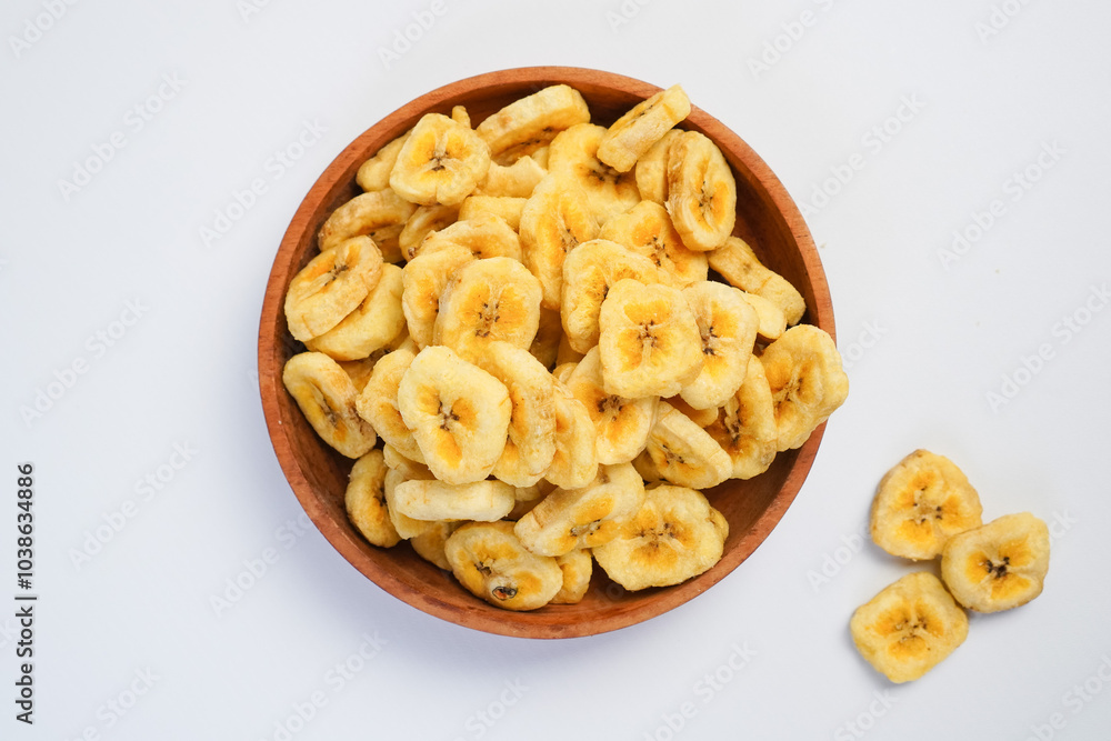 A bowl of banana chips is on a white background A bowl of banana chips is on a white background