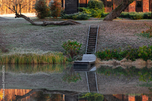 Autumn landscape with wooden stairs and boardwalk reflection in lake water photo