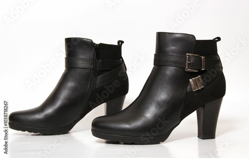 Black leather ankle boots with buckle detail. photo