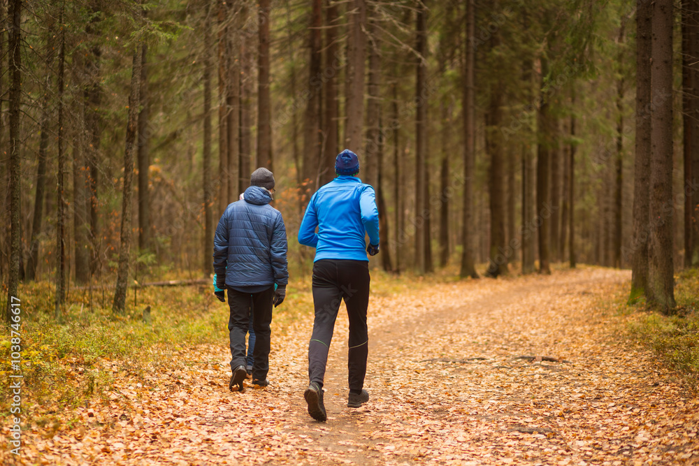 A man runs in an autumn park. Doing sports outside. A man runs in an autumn park. Doing sports outside.