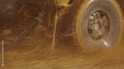 A close-up of an off-road vehicle's muddy tire and fender, with water and mud splashing up as it navigates challenging terrain. Extreme mud racing. Slow motion photo