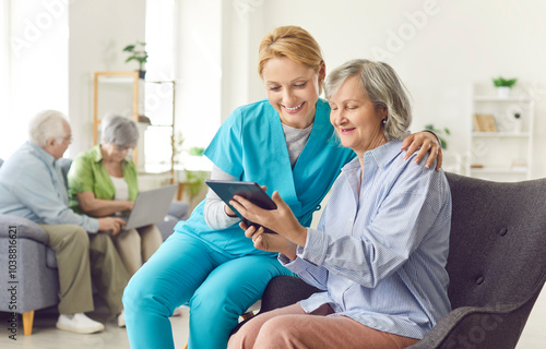 Fotografía Caring kind smiling nurse, geriatric medicine caretaker watching photos or video