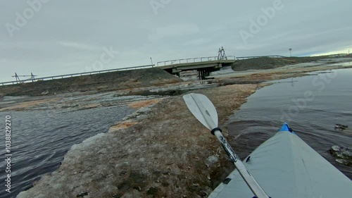 A kayaker navigates through icy waters, showcasing the beauty and danger of this extreme sport.