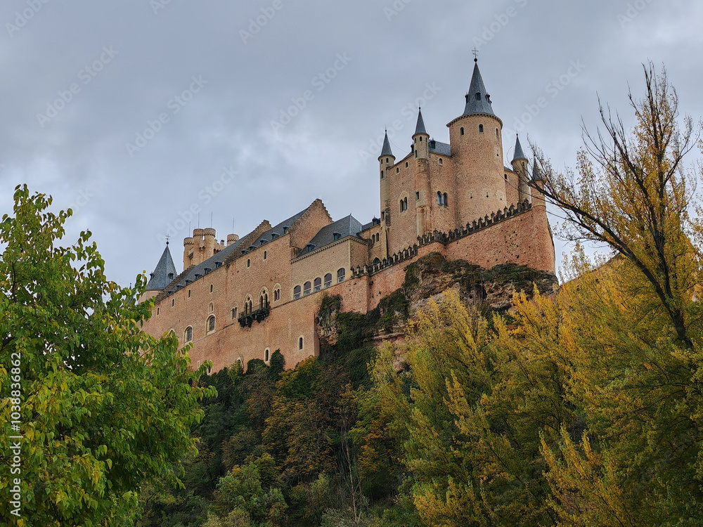 The Alcazar Castle of Segovia on an autumn day with cloudy sky and brass colors The Alcazar Castle of Segovia on an autumn day with cloudy sky and brass colors