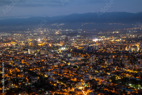 Night city panorama with illuminated buildings. Aerial view of a modern city at night. Night panorama urban silhouettes, a symphony of lights. The city seen from above.