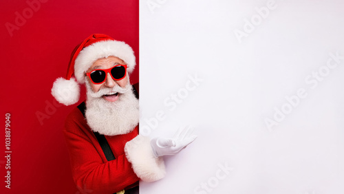 Portrait of funky Santa Claus looking behind white wall advertising winter x-mas shopping seasonal miracle sales discounts