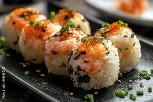 Japanese rice balls called Temarizushi featuring shrimp crab salmon and eel presented on a black plate at the restaurant Close up view photo