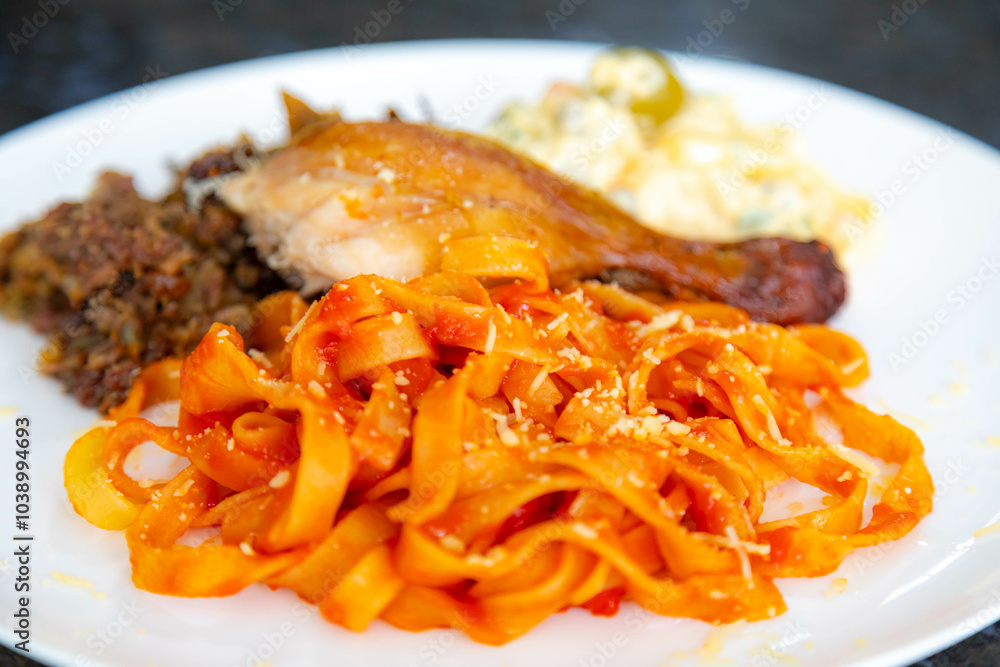 Traditional Brazilian Sunday lunch, pasta, roast chicken and mayonnaise salad with potatoes Traditional Brazilian Sunday lunch, pasta, roast chicken and mayonnaise salad with potatoes