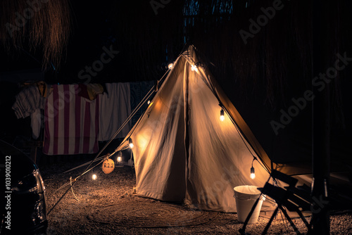 Beautiful, well-kept campsite at night. Tents with lanterns, romantic atmosphere. Night photos of modern Glamping
