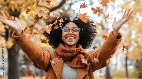 Casual joyful woman having fun trowing leaves in autumn