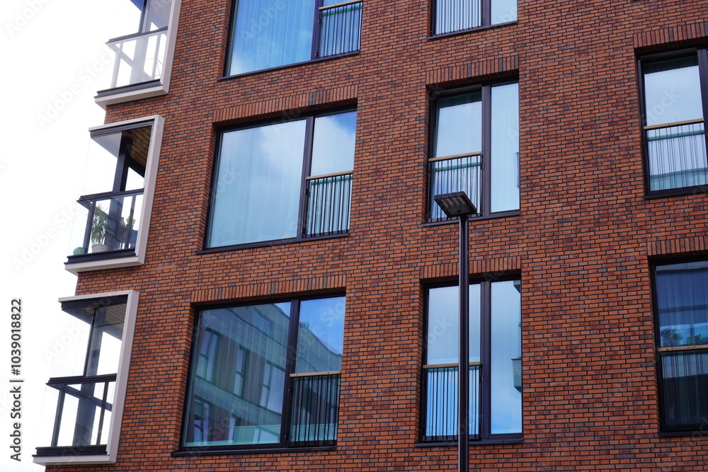 Fototapeta premium Modern red brick building with large reflective windows and minimalistic design. Noblessner, Tallinn, Tallinn, Estonia. August 2024