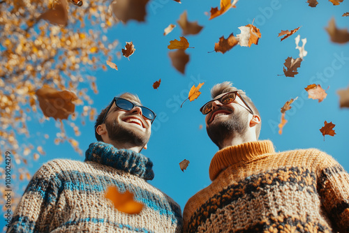 Gay couple or two boyfriends Sunny weather hipster people Romantic walk, happy couple with warm pullovers in autumn park. Smiling friends hugging in falling leaves. smiling in golden autumn leaves. photo